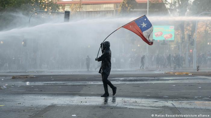 Un manifestante enarbola una bandera de Chile durante unas protestas en enero de 2021